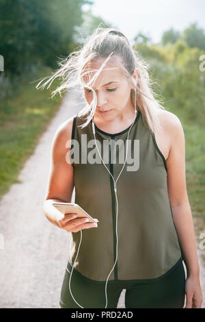 Blond sport Frau joggt in Park Stockfoto