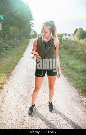 Blond sport Frau joggt in Park Stockfoto