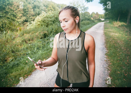 Blond sport Frau joggt in Park Stockfoto