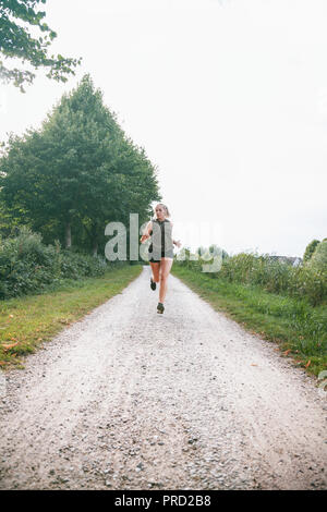 Blond sport Frau joggt in Park Stockfoto