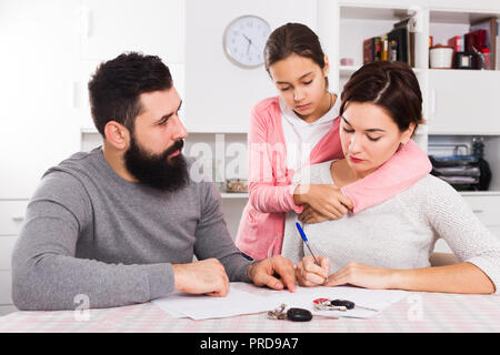 Unglücklich junger Vater und Mutter vorbereiten Scheidung während ihr Kind zu Hause Stockfoto