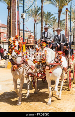 Spanier in traditionellen festlichen Kleid auf dekoriert Pferdekutsche, Feria de Caballo, Jerez de la Frontera Stockfoto