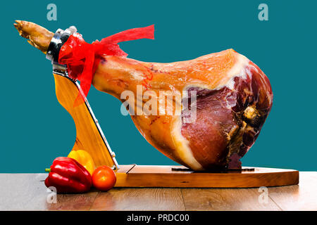 Parma Schinken (Jamón) auf einem Stand aus Holz auf blauem Hintergrund isoliert Stockfoto