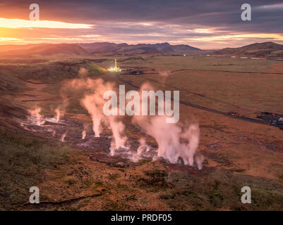 Dampfende Bohrlöchern und Bohranlage, Hverahlidarvirkjun Geothermiekraftwerk, Island Stockfoto