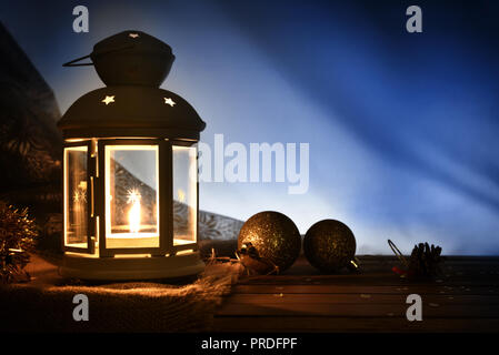 Komposition mit Laternen beleuchteten und Weihnachten Dekoration auf hölzernen Tisch in der Dunkelheit. Horizontale Zusammensetzung Stockfoto