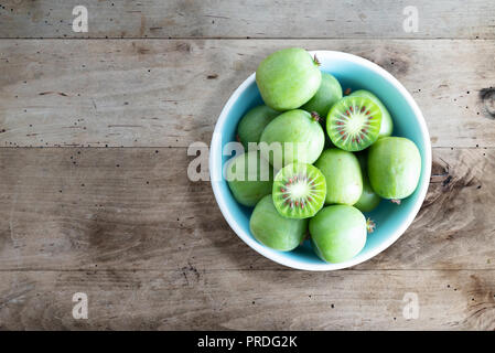 Hardy Kiwis oder kiwi Beeren in Keramik Schüssel auf dem Tisch Stockfoto