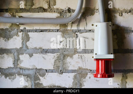 Red industrielle Gerät Anschluss auf einer Mauer. Stockfoto