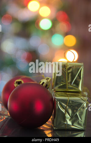 Einige Weihnachtsdekorationen mit Weihnachtsbeleuchtung unscharf im Hintergrund Stockfoto