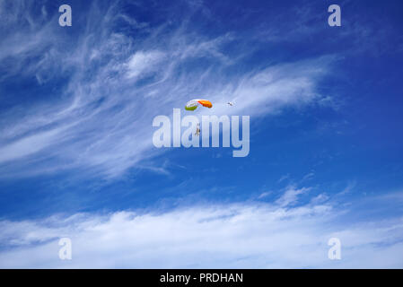 Helle weisse Fallschirm Vordach und Tandem skydivers vor dem Hintergrund der ungewöhnlich schöne Wolken und blauer Himmel. Tandem Master mit Passagier ich Stockfoto