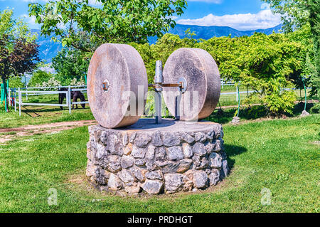 Alte Olivenpresse mit zwei Mühlsteinen in der Landschaft Stockfoto