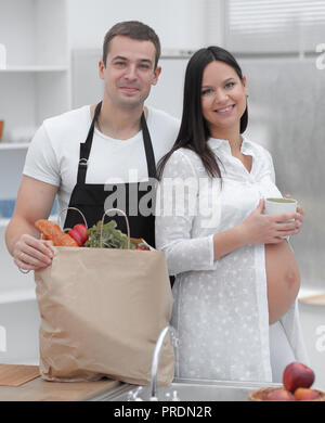 Glückliches Paar neben der Packung, stehen in der Küche. Stockfoto