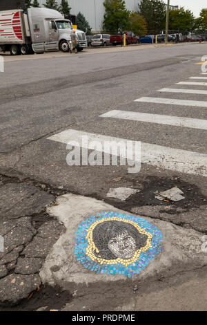 Detroit, Michigan - ein Schlagloch mit einem künstlerischen Mosaik von Aretha Franklin auf einer Straße in den östlichen Markt Bezirk gepatcht. Chicago Künstler Jim Bachor Stockfoto