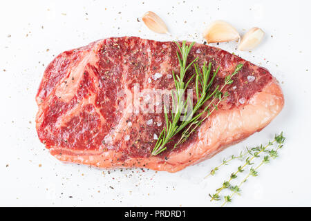 Raw Roastbeef Rindersteak mit Rosmarin, Thymian, Salz und Pfeffer. gegen Weiße isoliert. top View Stockfoto