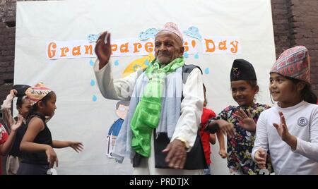 Kathmandu, Nepal. 1. Okt, 2018. Ein älterer Mann Tänze mit Kindern während einer Feier zum Internationalen Tag der älteren Menschen in einer örtlichen Schule in Kathmandu, Nepal, Oktober 1, 2018. Am Dez. 14, 1990 die UNO-Generalversammlung 1. Oktober eines jeden Jahres zum Internationalen Tag der Älteren Menschen ernannt. Credit: Sunil Sharma/Xinhua/Alamy leben Nachrichten Stockfoto