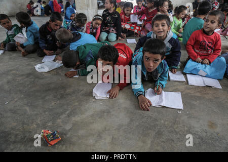 Idlib, Syrien. 01 Okt, 2018. Vertriebene syrische Kinder besuchen die Klasse auf einen provisorischen Schule innerhalb eines alten Moschee erbaut, im östlichen Umland von idlib Provinz. Nach sieben Jahren des brutalen syrischen Krieg, mehr als 6 Millionen Menschen, darunter 2,5 Millionen Kinder sind intern Vertriebene, und einem in drei syrischen Schulen kann nicht verwendet werden, da sie entweder beschädigt ist, oder für das Schützen der vertriebenen Familien und für militärische Zwecke verwendet, entsprechend dem Hohen Kommissar der Vereinten Nationen für Flüchtlinge (UNHCR). Credit: Anas Alkharboutli/dpa/Alamy leben Nachrichten Stockfoto