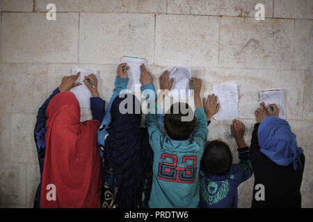 Idlib, Syrien. 01 Okt, 2018. Vertriebene syrische Kinder besuchen eine provisorische Schule innerhalb eines alten Moschee erbaut, im östlichen Umland von idlib Provinz. Nach sieben Jahren des brutalen syrischen Krieg, mehr als 6 Millionen Menschen, darunter 2,5 Millionen Kinder sind intern Vertriebene, und einem in drei syrischen Schulen kann nicht verwendet werden, da sie entweder beschädigt ist, oder für das Schützen der vertriebenen Familien und für militärische Zwecke verwendet, entsprechend dem Hohen Kommissar der Vereinten Nationen für Flüchtlinge (UNHCR). Credit: Anas Alkharboutli/dpa/Alamy leben Nachrichten Stockfoto