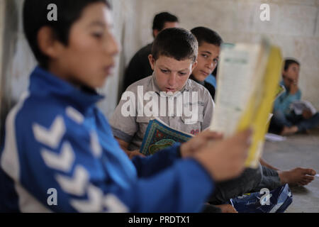 Idlib, Syrien. 01 Okt, 2018. Vertriebene syrische Kinder besuchen die Klasse auf einen provisorischen Schule innerhalb eines alten Moschee erbaut, im östlichen Umland von idlib Provinz. Nach sieben Jahren des brutalen syrischen Krieg, mehr als 6 Millionen Menschen, darunter 2,5 Millionen Kinder sind intern Vertriebene, und einem in drei syrischen Schulen kann nicht verwendet werden, da sie entweder beschädigt ist, oder für das Schützen der vertriebenen Familien und für militärische Zwecke verwendet, entsprechend dem Hohen Kommissar der Vereinten Nationen für Flüchtlinge (UNHCR). Credit: Anas Alkharboutli/dpa/Alamy leben Nachrichten Stockfoto