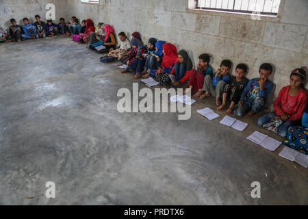 Idlib, Syrien. 01 Okt, 2018. Vertriebene syrische Kinder besuchen die Klasse auf einen provisorischen Schule innerhalb eines alten Moschee erbaut, im östlichen Umland von idlib Provinz. Nach sieben Jahren des brutalen syrischen Krieg, mehr als 6 Millionen Menschen, darunter 2,5 Millionen Kinder sind intern Vertriebene, und einem in drei syrischen Schulen kann nicht verwendet werden, da sie entweder beschädigt ist, oder für das Schützen der vertriebenen Familien und für militärische Zwecke verwendet, entsprechend dem Hohen Kommissar der Vereinten Nationen für Flüchtlinge (UNHCR). Credit: Anas Alkharboutli/dpa/Alamy leben Nachrichten Stockfoto