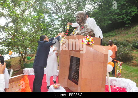 Jinja, Uganda. 2. Oktober, 2018: Der Hohe Kommissar von Indien in Uganda Ravi Shankar (links) garlanding Mahatma Gandhi's Statue mit Blumen während der Feierlichkeiten Mahatma Gandhi's 149. Geburtstag und Internationalen UN-Tag der Gewaltlosigkeit an der Quelle des Nils in Jinja zu markieren. Die Mitglieder der Indischen Verband Uganda, Beamte von busoga Königreich Tourismus Ministerium und Jinja Bewohner schlossen sich anderen Indianer auf der ganzen Welt feiert den 149. Geburtstag von Mahatma Gandhi und den Internationalen Tag der Gewaltlosigkeit. In Uganda, Sie garlanded Mahatma Gandhi's Statue mit Blumen. Credit: Dona Stockfoto