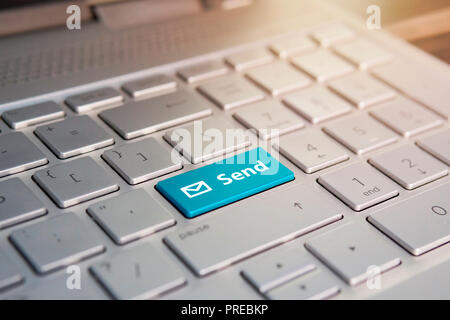 Blaue Schaltfläche Einreichen auf eine weiße Tastatur, Farbe auf dem Grau Silber Tastatur der modernen ultrabook. Auf der Schaltfläche Stockfoto