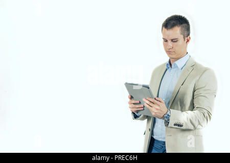 Ernsthafte junge männliche mit digitalen tablet Kontrolle Nachrichten oder Informationen in tablet pc Stockfoto