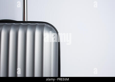 Teil einer grauen Koffer für Reisen auf einem grauen Hintergrund mit Kopie Raum Stockfoto