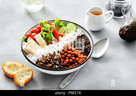 Buddha Schüssel. Sauber und gesund Gesunde Ernährung Konzept. Reis, würzige Kichererbsen, schwarz Quinoa, Gemüse und Hähnchenfilet auf grauem Beton Hintergrund t Stockfoto