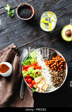 Buddha Schüssel. Sauber und gesund Gesunde Ernährung Konzept. Reis, würzige Kichererbsen, schwarz Quinoa, Gemüse und Hähnchenfilet auf dunklem Hintergrund, Stockfoto