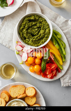 Gemüse Snacks mit Pesto auf Platte top Aussicht serviert. Pfeffer, Sellerie, Rhabarber, Cherry Tomaten, Radieschen mit Pesto Stockfoto