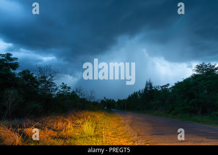 Die Straße, die der Regen vom dicken Nimbus cloud führt Stockfoto