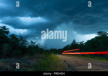 Die Straße, die der Regen vom dicken Nimbus cloud führt Stockfoto