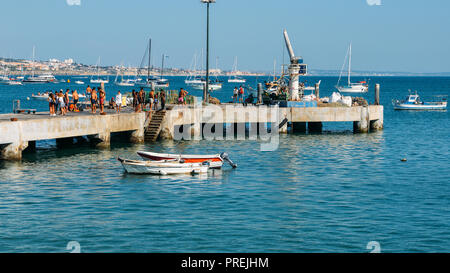 Cascais, Portugal - Sept 29, 2018: Junge Leute springen aus dem Pier auf die Bucht von Cascais an einem sonnigen Sommertag Stockfoto