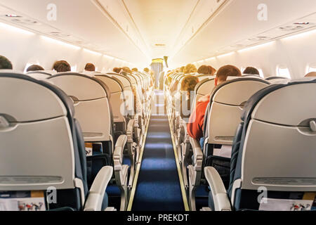 Verkehrsflugzeuge Kabine mit Sitzreihen den Gang hinunter. morgen Licht im Salon der Airliner. Economy Class Stockfoto
