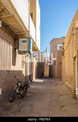 YAZD, IRAN - August 9, 2018: zwei motorcycyles in eine typische Straße der Altstadt von Yazd, Iran stehend, mit seinen typischen Lehm Wände und Gebäude. Yaz Stockfoto