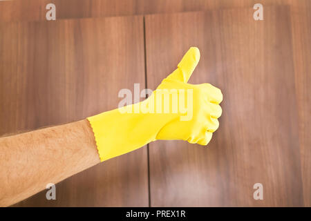 Reinigung Erfolg. Daumen hoch von Hand in gelb Schutzhandschuh Stockfoto
