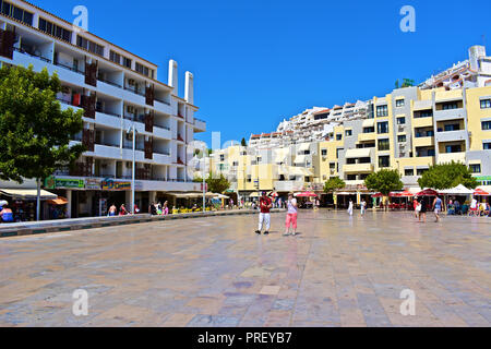 Touristen schlendern über Square dos Pesdores - einer modernen zentralen Platz im Herzen der Altstadt von Albufeira, die zum Strand führt. Algarve, Portugal Stockfoto