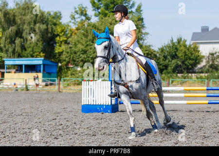 Junge Reiterin Mädchen Galopp auf ihrem Kurs in Reitturnier Stockfoto