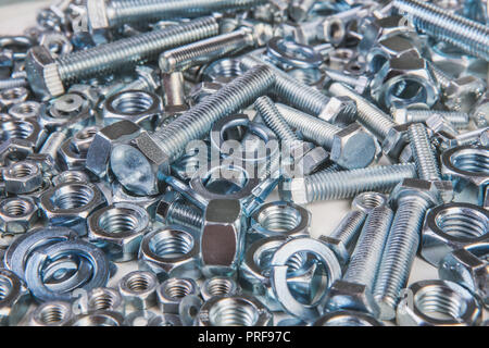 Verchromte Schrauben und Muttern auf weißem Hintergrund Stockfoto