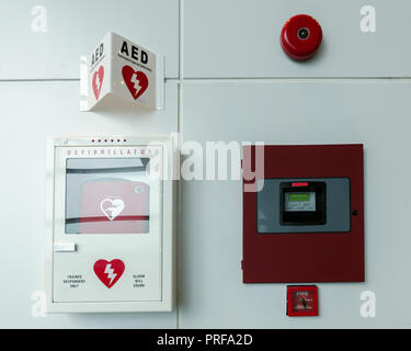 Allgemeine Ansicht eines lebensrettenden Defibrillator. Tragbare automatisierten externen Defibrillator (AED) und Brandmeldeanlage an der Wand Stockfoto