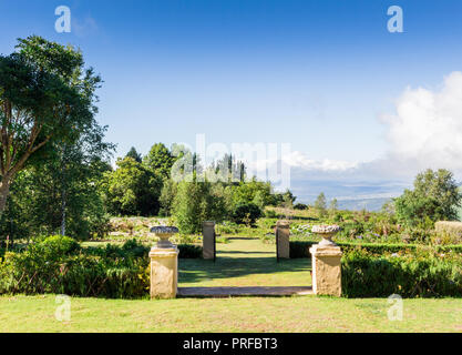 Garten mit Wänden und Dekorative Blumentöpfe am Rande von Hogsback, östliches Kap, Südafrika mit Blick auf ein Tal, mit Labyrinth in backgou Stockfoto