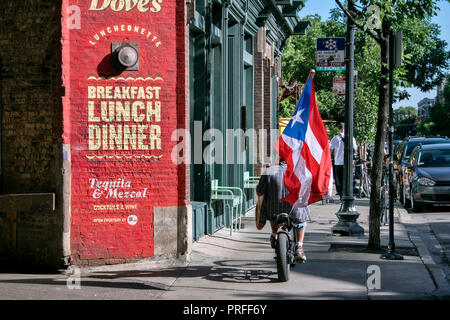 Radfahrer mit Puerto Rican flag Neben Taube's Luncheonette, Restaurant,Damen Avenue, Wicker Park, Chicago, Illinois, USA Stockfoto