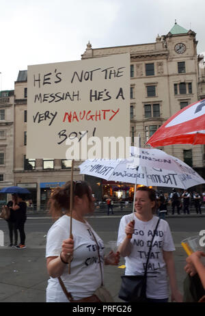 London, GB, 13. Juli 2018. 100.000 Menschen protestieren gegen den Besuch des US-Präsidenten Donald Trump. Die Demonstranten versammeln sich auf dem Trafalgar Square. Eine Frau hält einen placade mit einer Nachricht aus dem Film "Das Leben des Brian", ein anderer hält einen Regenschirm mit eine Nachricht geschrieben. Stockfoto