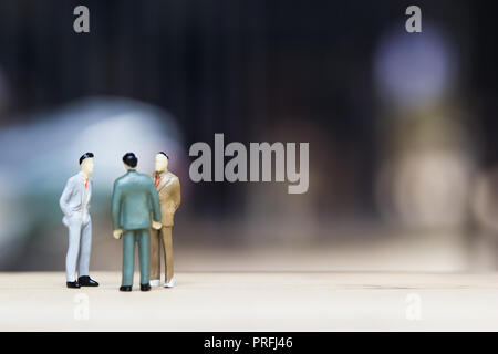 Finanzielle Investitionen Verhandlung, Diskussion unter den CEO oder Konzept ausführen: Miniatur Figur drei Unternehmer über Geld reden investieren Vertrag agr Stockfoto
