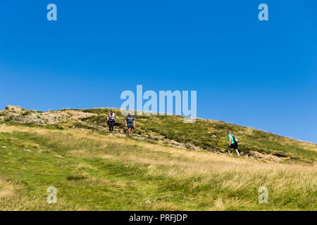 Drei Wanderer nähern sich einander auf den Fußweg Richtung Süden vom Gipfel des Cat Glocken (451 Meter) in der Nähe von Keswick, Cumbria. Stockfoto