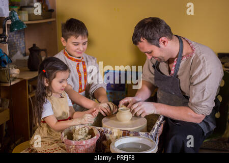 Keramik Klasse und Workshop: Professionelle männlichen Potter, die mit Kindern arbeiten und zeigen, wie keramische Waren in der Keramik Studio zu machen. Handgefertigte, educatio Stockfoto