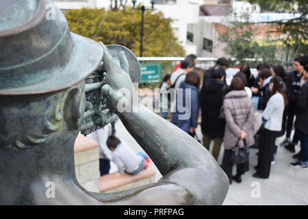 Versammlung von Menschen mit Statue im Vordergrund im Kitanocho, Kobe, Japan Stockfoto