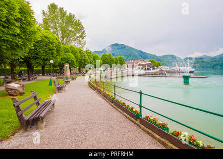 Uferstraße Promenade mit Bänken in der alpinen See Wolfgangsee, St. Gilgen, Österreich Stockfoto