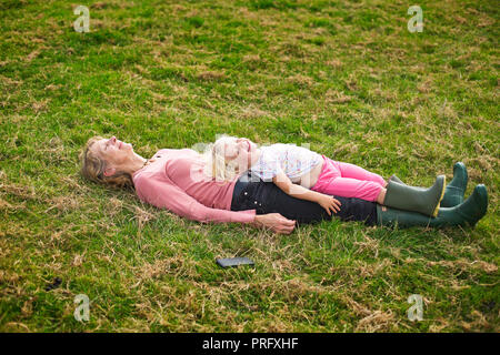 Ein Kind liegen mit ihrer Großmutter Stockfoto