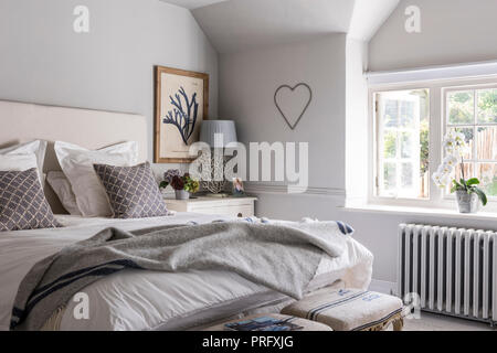 Ungemachten Bett im Zimmer mit Herz, Devon Cottage Stockfoto