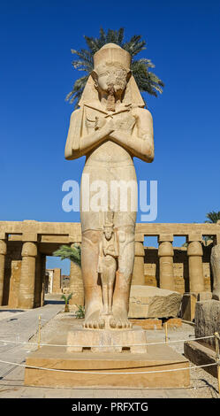 Eine Statue von Ramses II. mit dem kleineren Statue von seiner Tochter Verbogen'anta am Karnak Komplex, oder Tempel von Karnak, Luxor, Ägypten Stockfoto